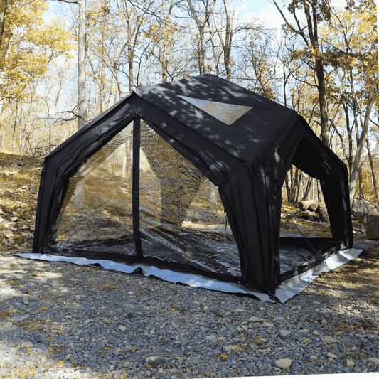 Black inflatable shelter in a forest setting