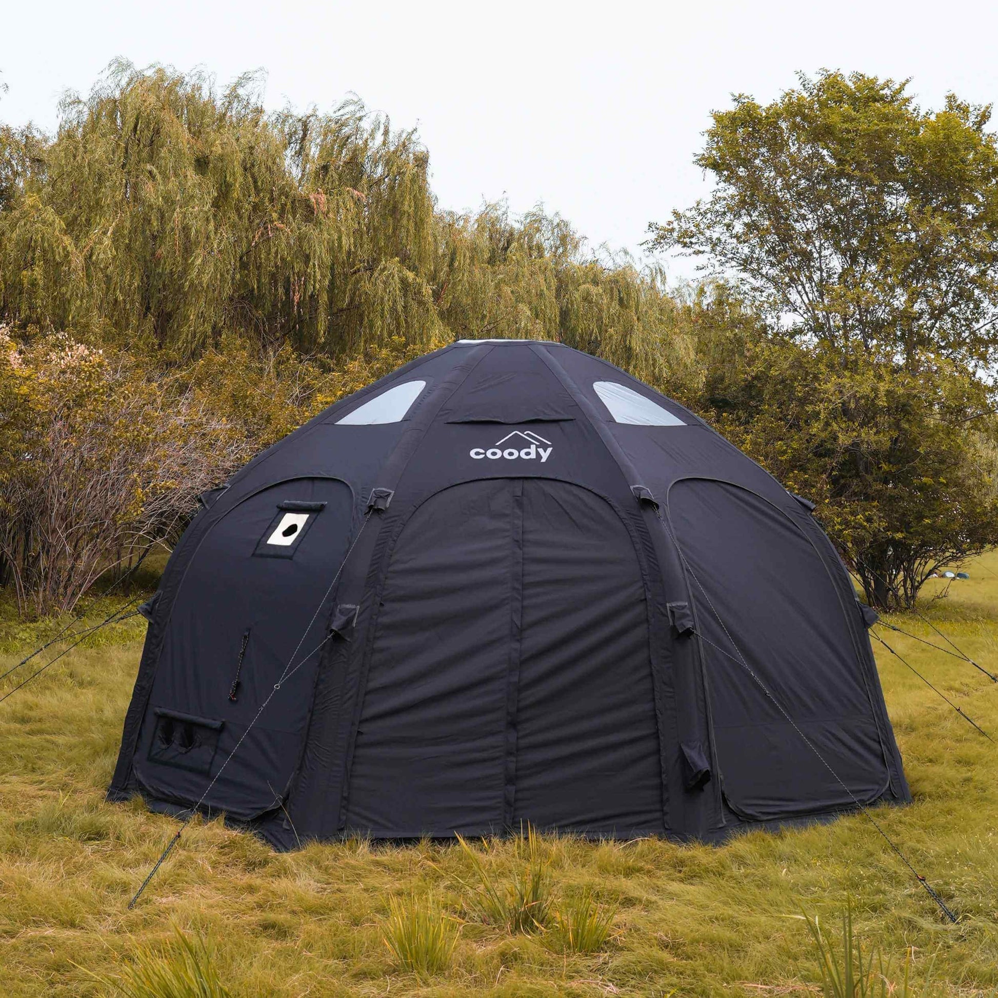 Black Coody tent in a grassy outdoor